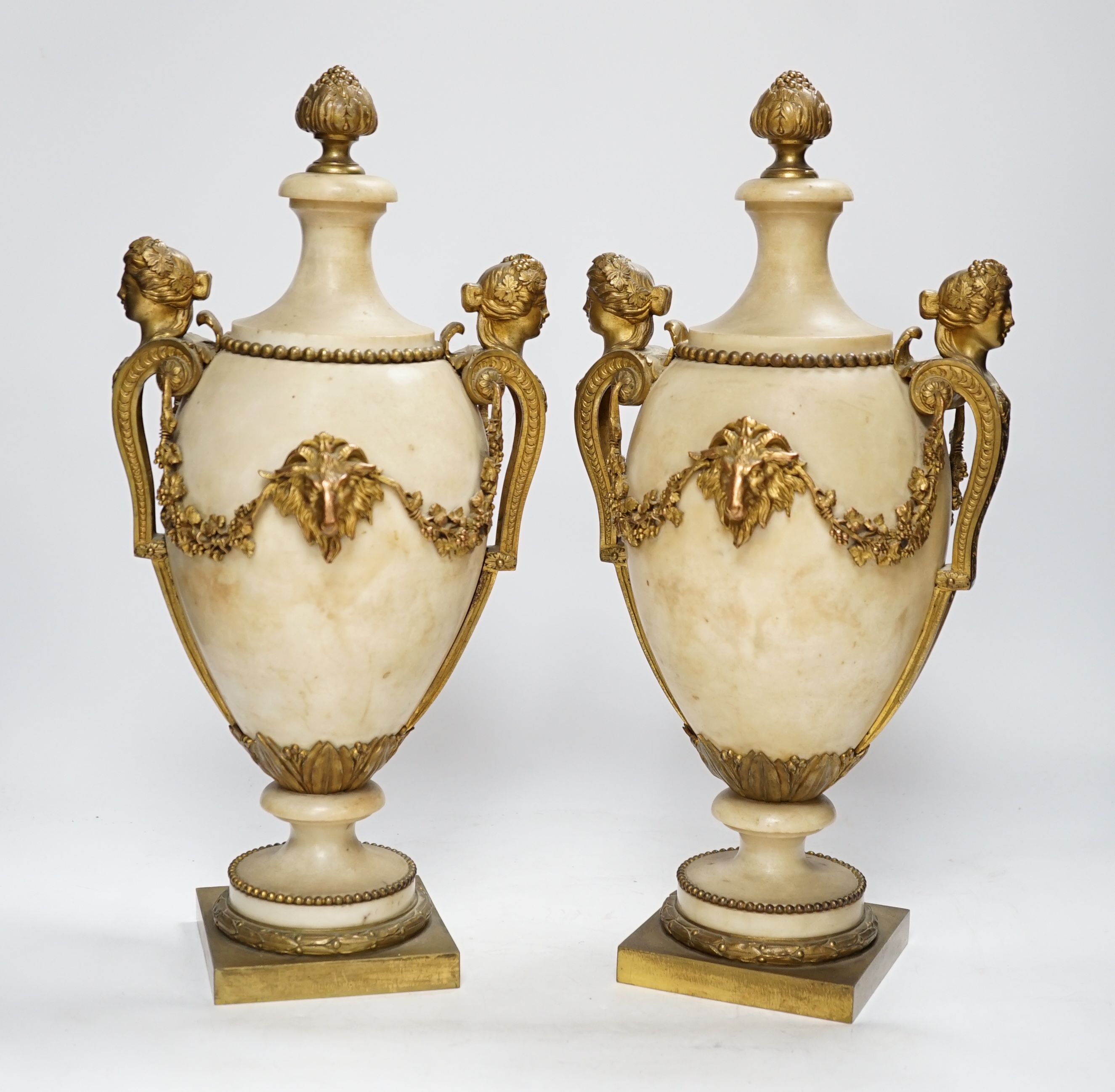 A pair of Adam style gilt metal mounted alabaster urns, 42cm high